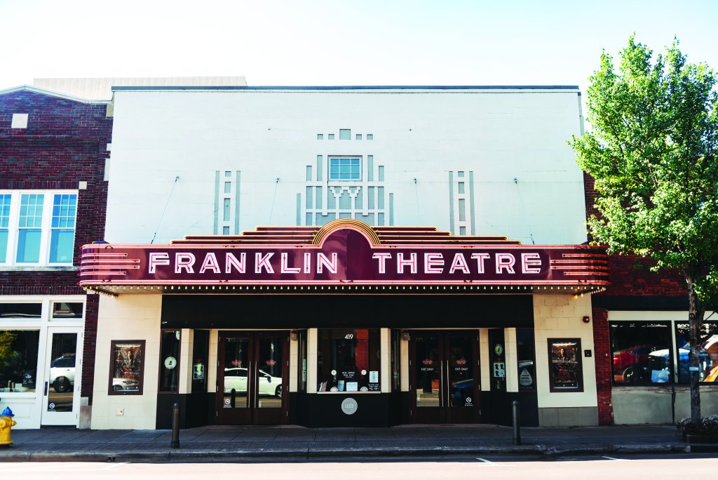 The Franklin Theatre, a vintage movie theater with a distinctive Art Deco marquee, stands prominently on a street corner in Williamson County, Tennessee.