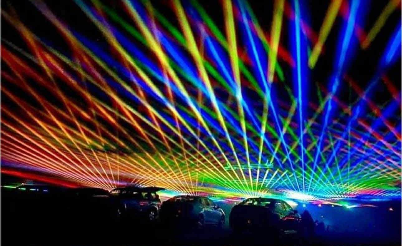 A mesmerizing display of colorful laser lights illuminates the night sky above a row of parked cars in Williamson County, Tennessee.