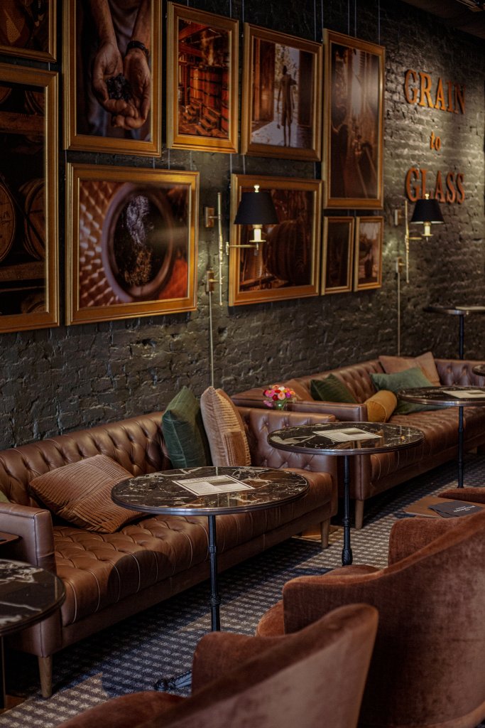 A cozy, rustic-chic lounge with leather sofas, marble-topped tables, and framed photographs on exposed brick walls in Williamson County, Tennessee.