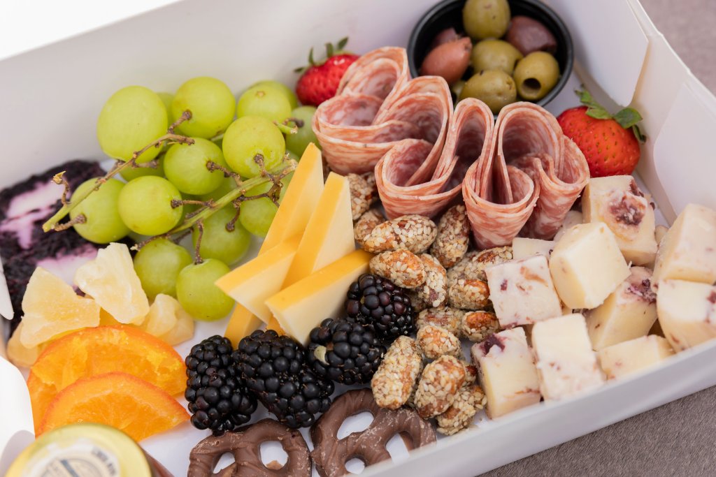 Events A colorful charcuterie board featuring grapes, cheese, cured meats, olives, berries, nuts, and citrus fruits in Williamson County, Tennessee.