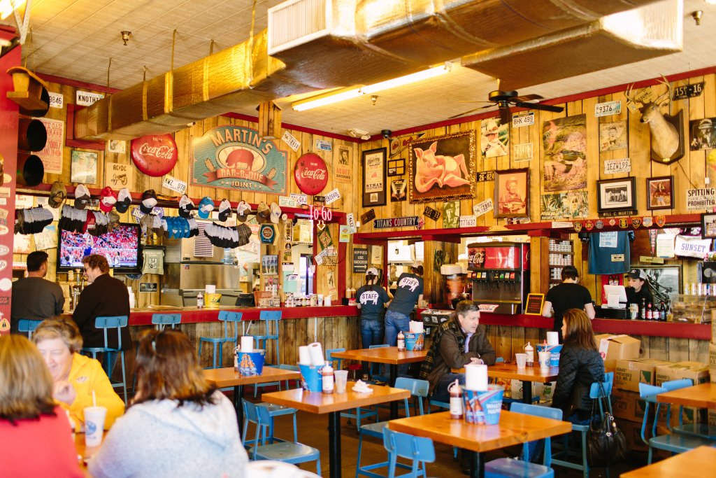 A lively diner with wooden walls covered in vintage signs and memorabilia, filled with patrons enjoying burgers and shakes in Williamson County, Tennessee.