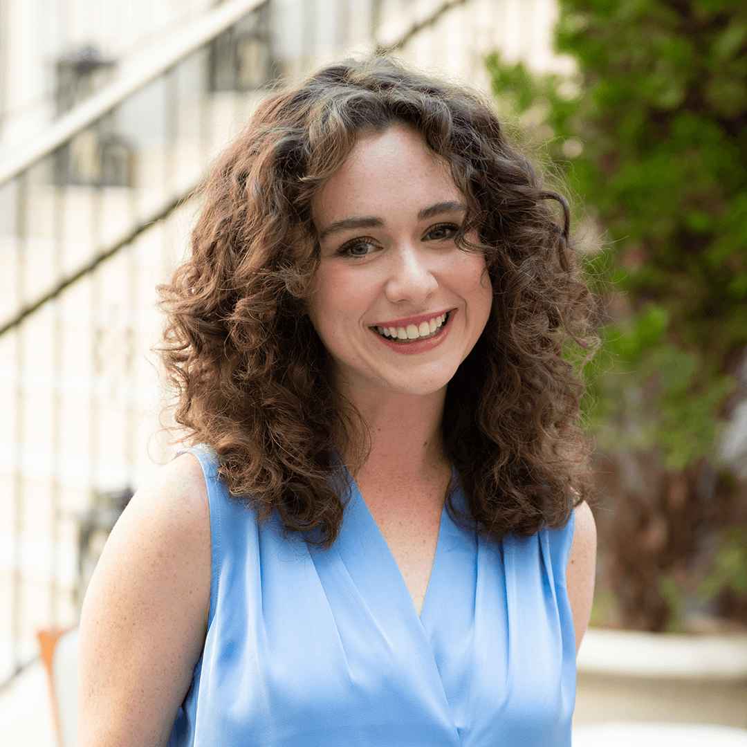 Matt Maxey A woman with curly hair is smiling brightly, wearing a blue sleeveless top in Williamson County, Tennessee.