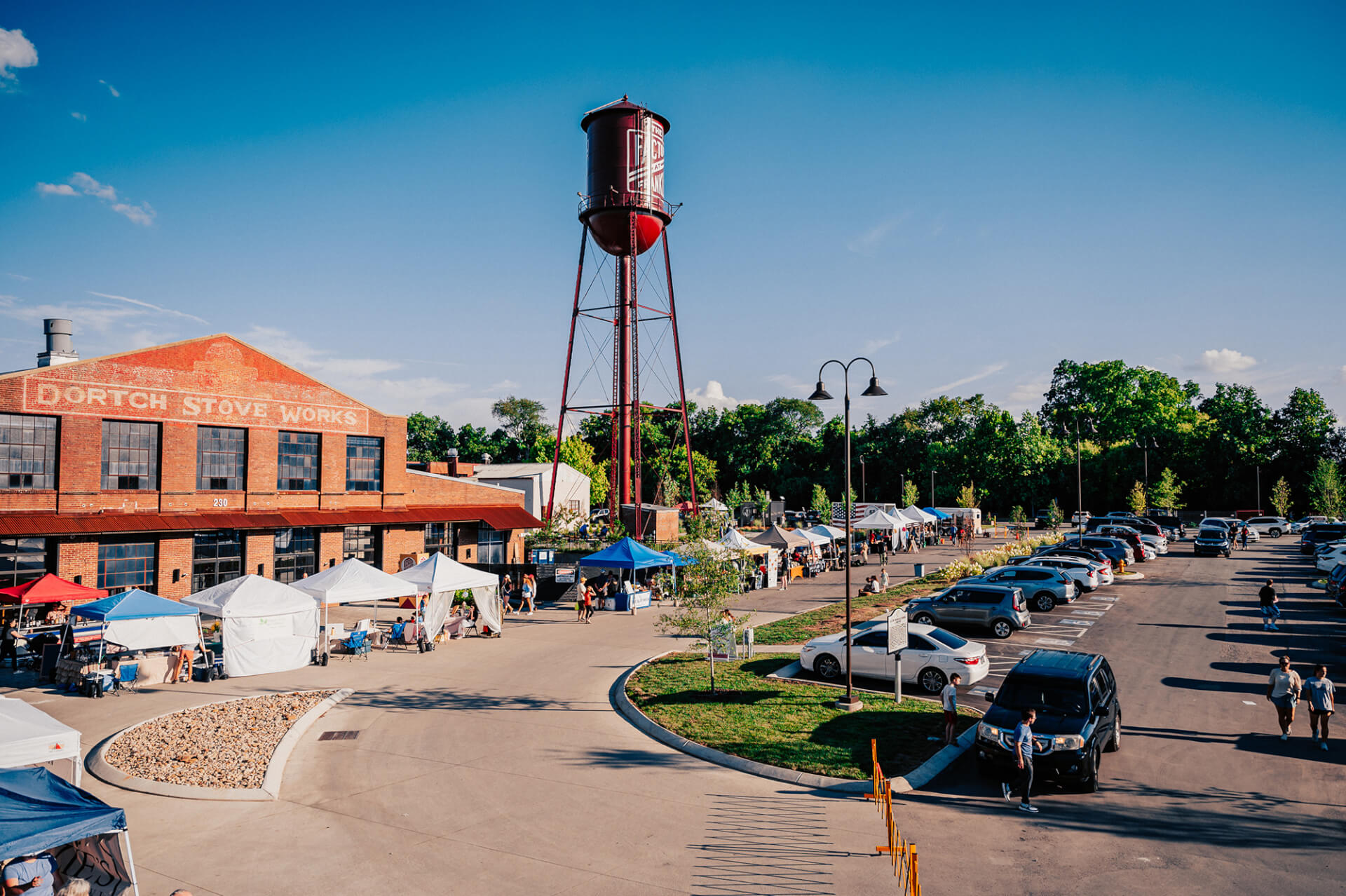 A bustling outdoor market with colorful tents and a historic water tower in the background in Williamson County, Tennessee.