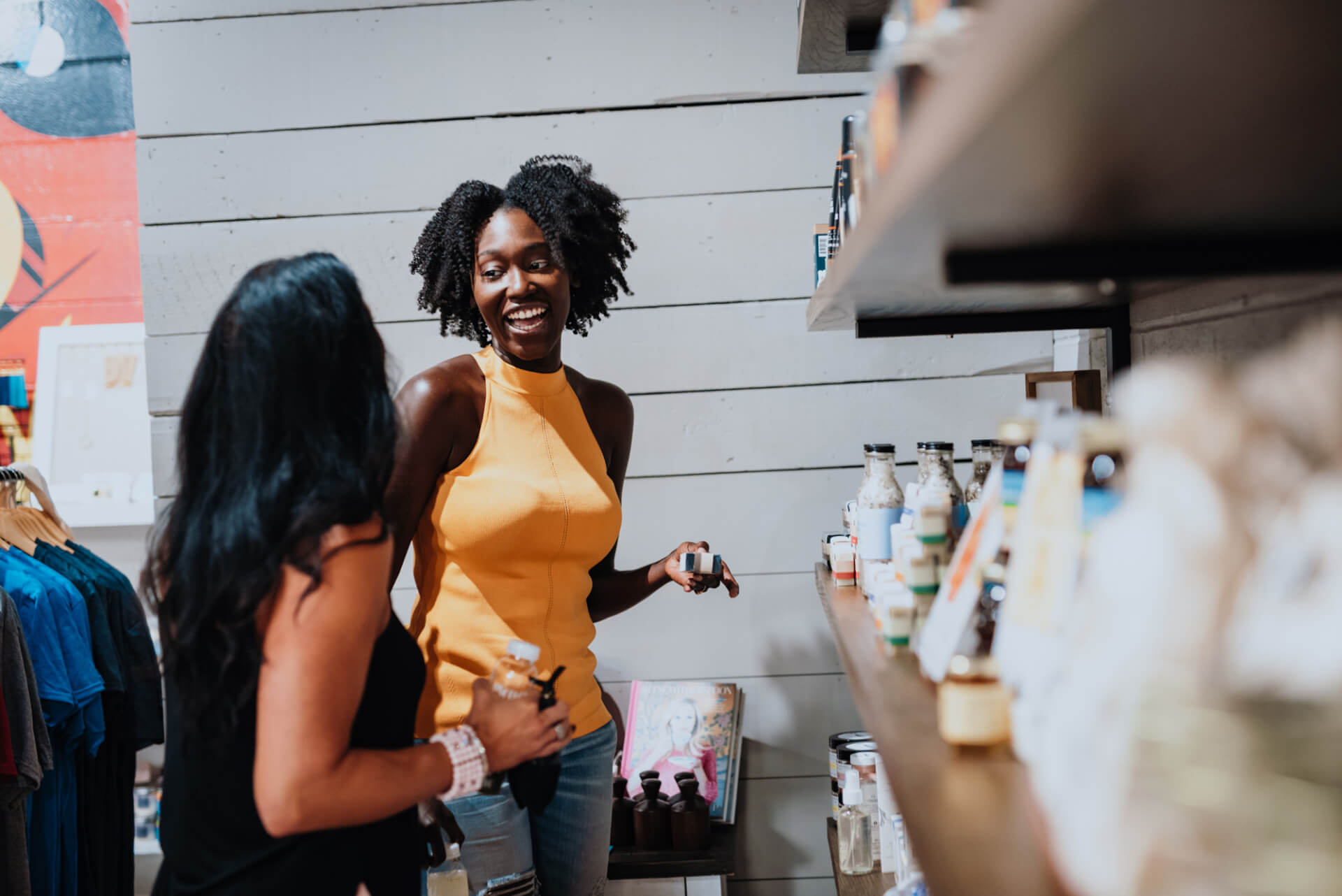 Two women are browsing and chatting in a store filled with various products on shelves in Williamson County, Tennessee.