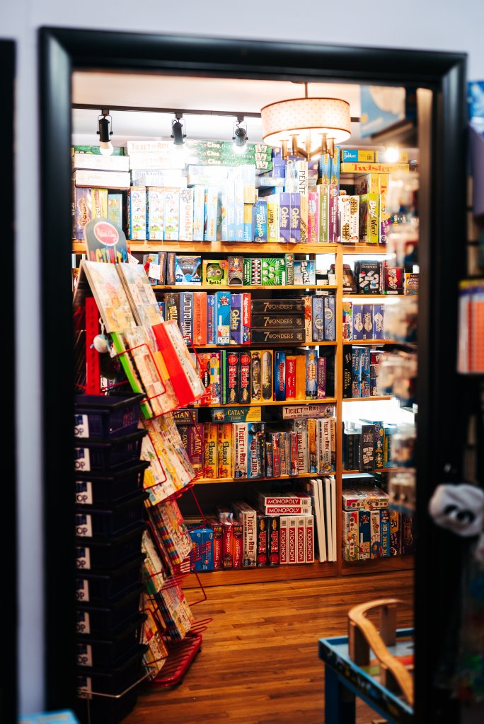A vibrant game store filled with colorful board games and puzzles displayed on shelves and racks in Williamson County, Tennessee.