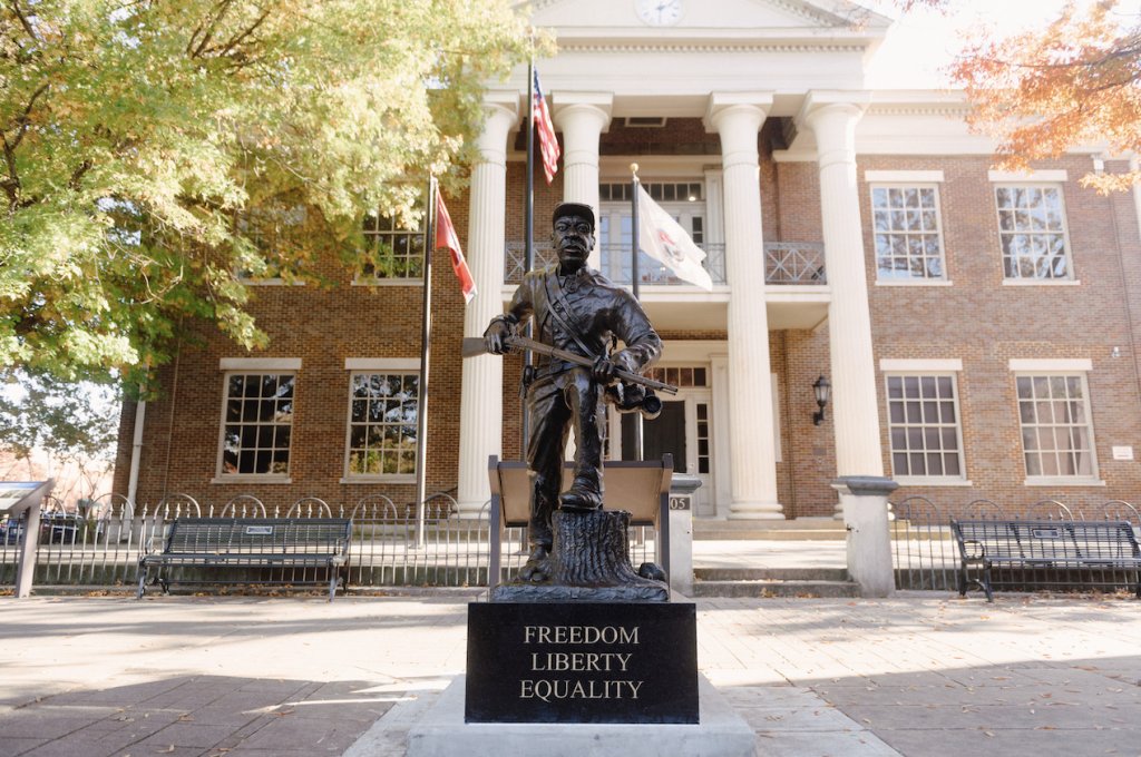End of Summer Escape A bronze statue of a soldier stands proudly in front of a historic courthouse, with the words 'Freedom, Liberty, Equality' inscribed at its base in Williamson County, Tennessee.