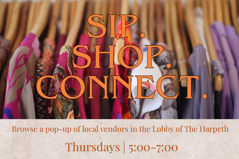 A colorful array of clothing on hangers with a sign advertising a local vendor pop-up event in Williamson County, Tennessee.