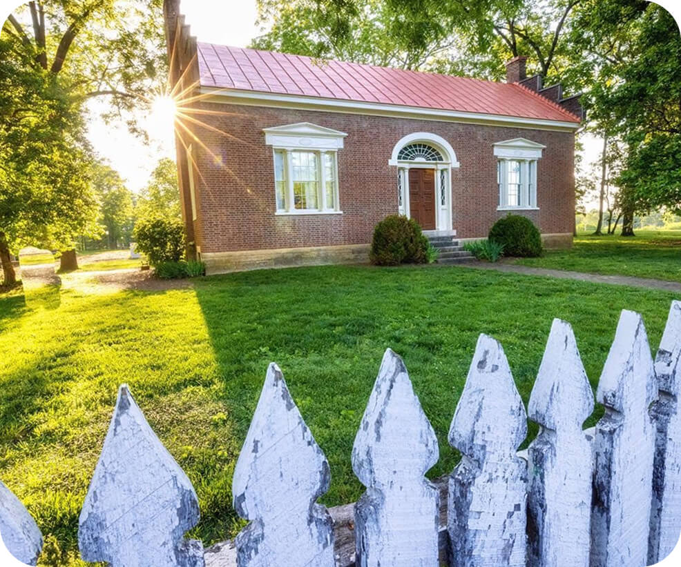Top 10 Things to Do in Franklin A historic brick house with a red roof behind a white picket fence in Williamson County, Tennessee.
