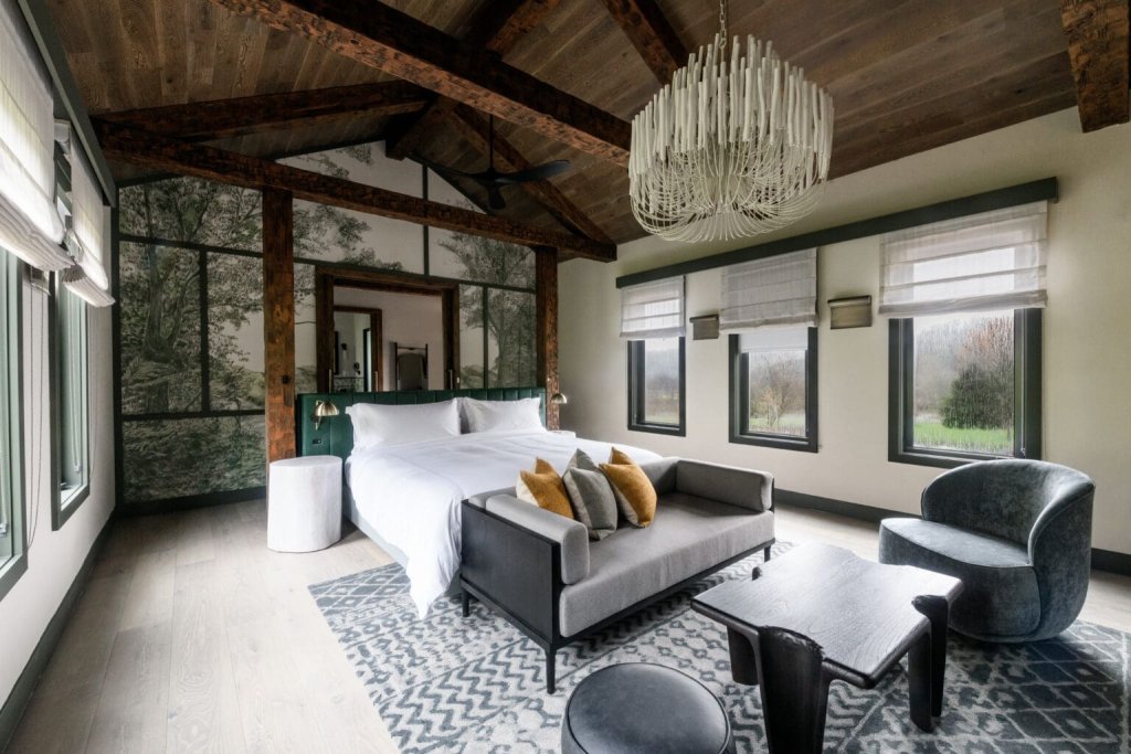 Top 10 Things to Do in Franklin A luxurious bedroom with a vaulted ceiling, forest mural, and modern furniture in Williamson County, Tennessee.