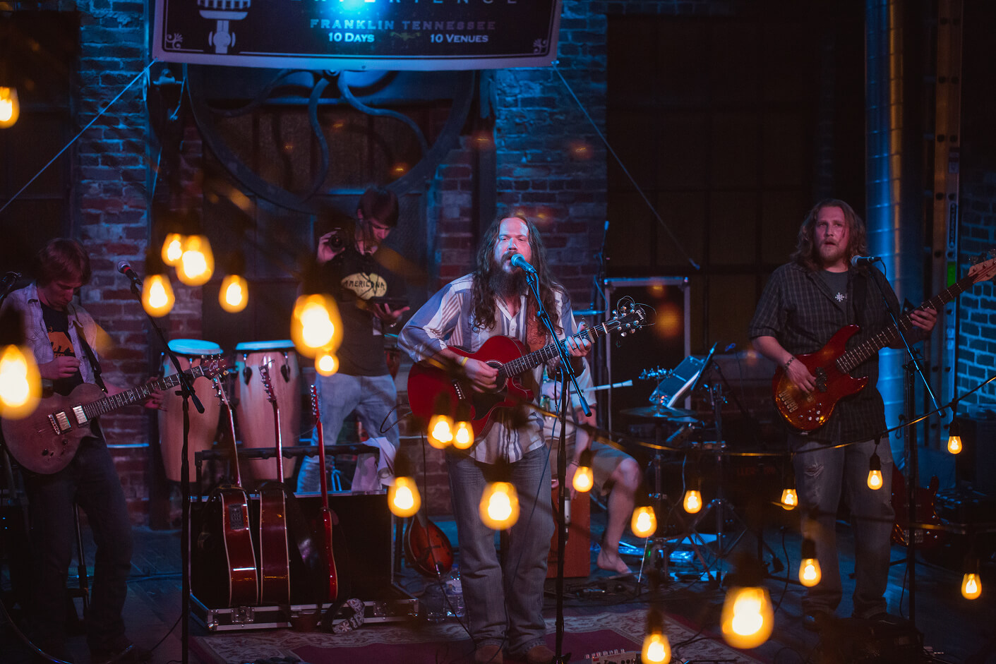 Top 10 Things to Do in Franklin A band performs on a dimly lit stage decorated with hanging string lights in Williamson County, Tennessee.