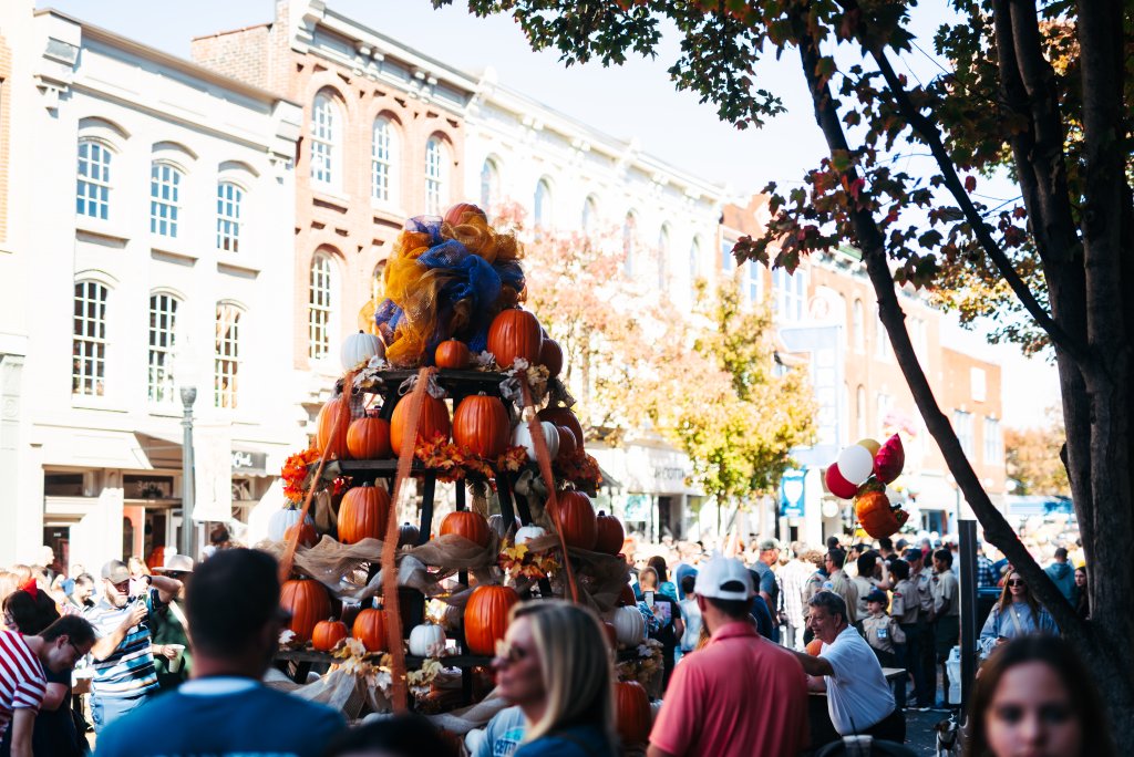 A large tiered pumpkin display stands in a crowded street during an autumn festival in Williamson County, Tennessee.