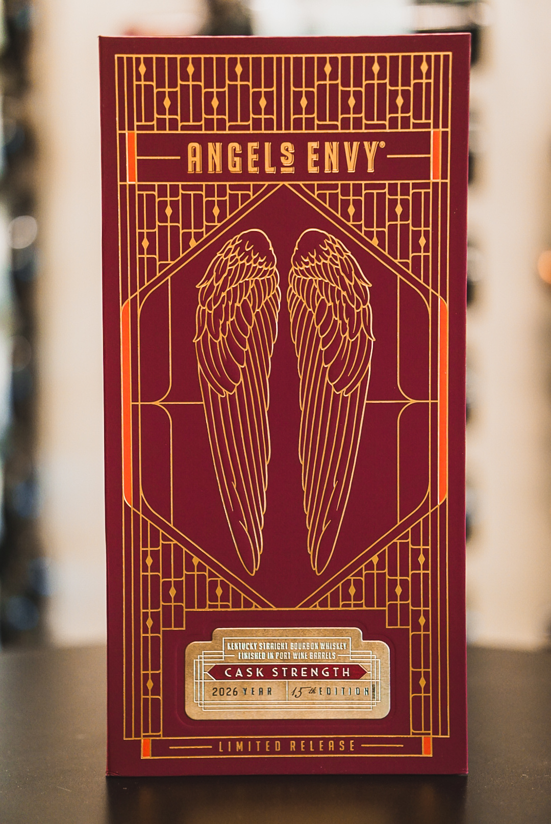 Angel's Envy Bourbon Tasting + Engraving A maroon box for Angel's Envy Cask Strength bourbon with gold art deco wing designs in Williamson County, Tennessee.