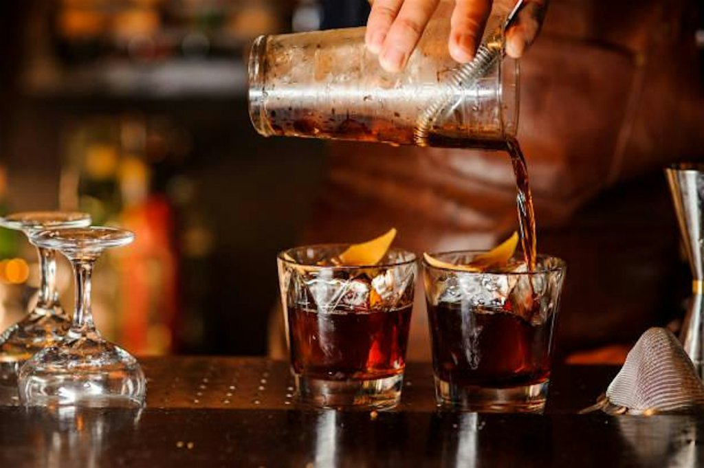 Events A bartender pours a dark cocktail into glasses with ice and orange peels in Williamson County, Tennessee.