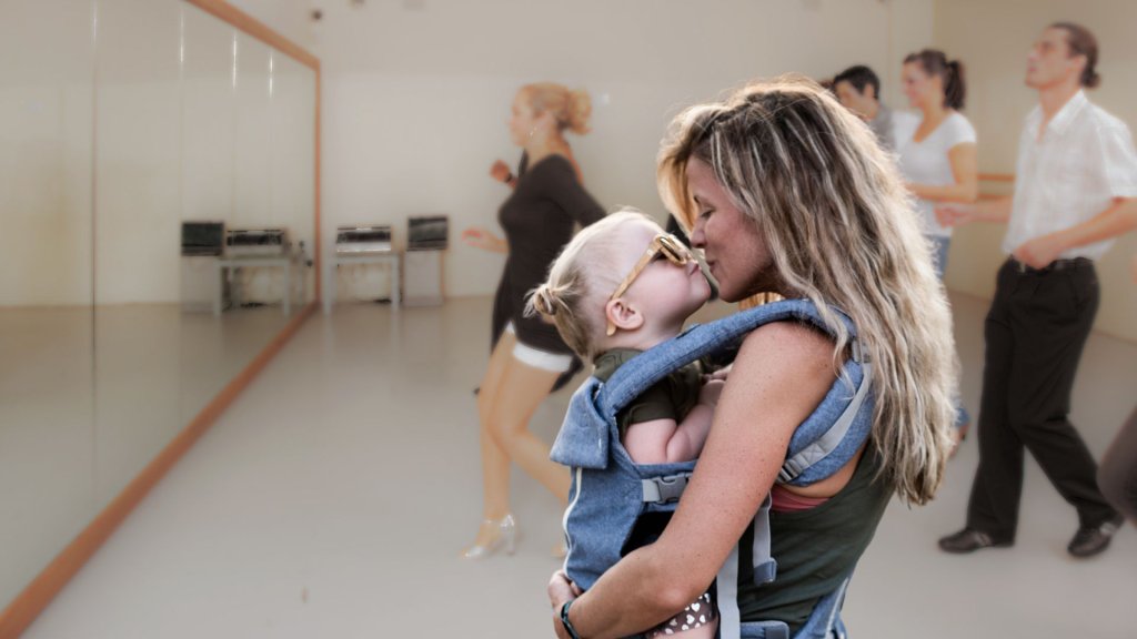 Events A mother wearing a baby carrier kisses her toddler in a dance studio in Williamson County, Tennessee.
