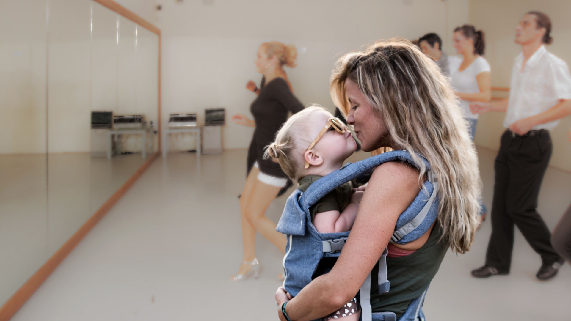 Baby and Me Line Dancing A mother wearing a baby carrier kisses her toddler in a dance studio in Williamson County, Tennessee.