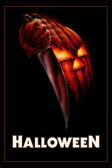 A hand holding a knife in front of a glowing jack-o'-lantern in Williamson County, Tennessee.
