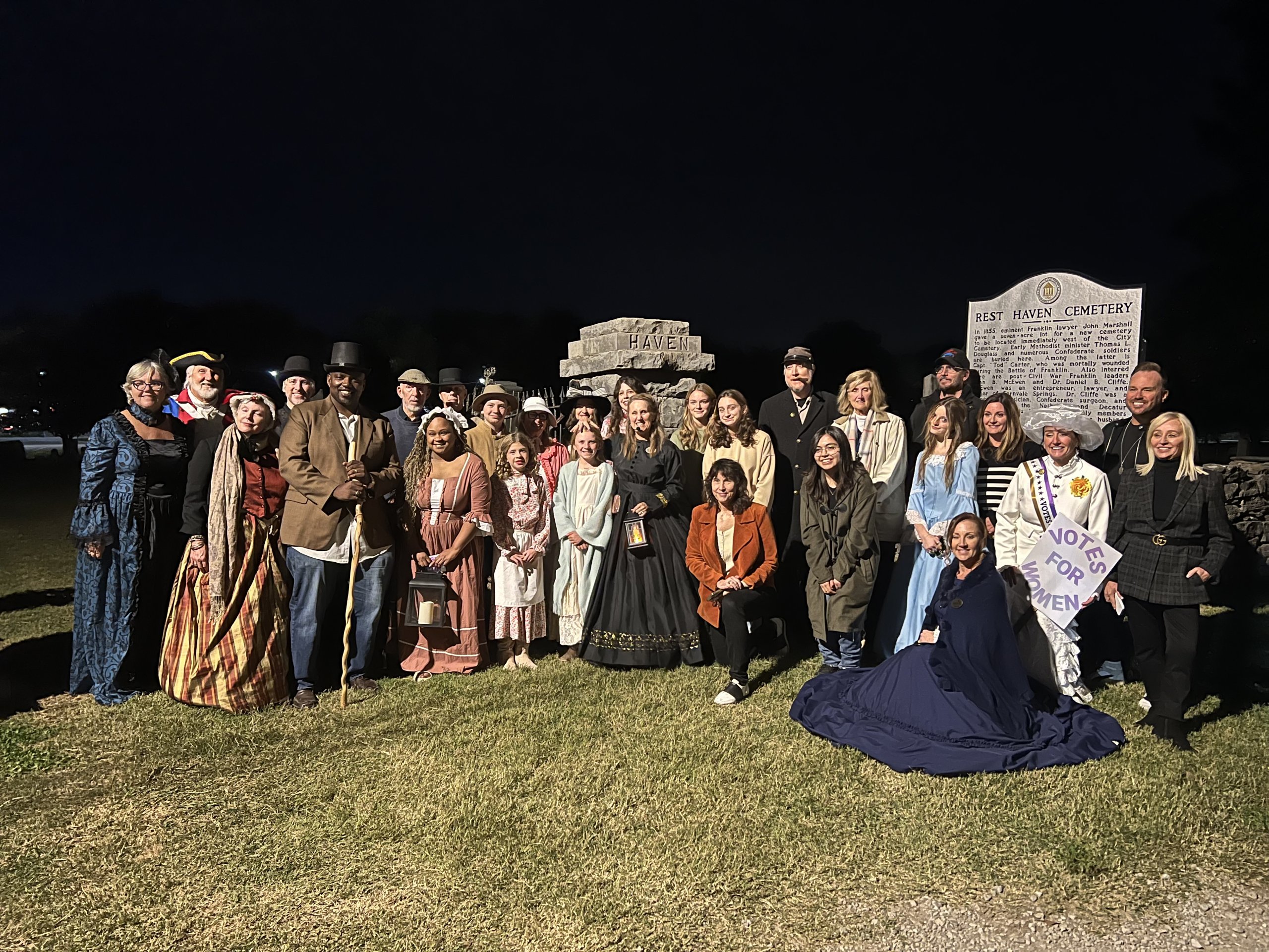 TOMBSTONE TALES A group of people in historical costumes posing at Rest Haven Cemetery at night in Williamson County, Tennessee.