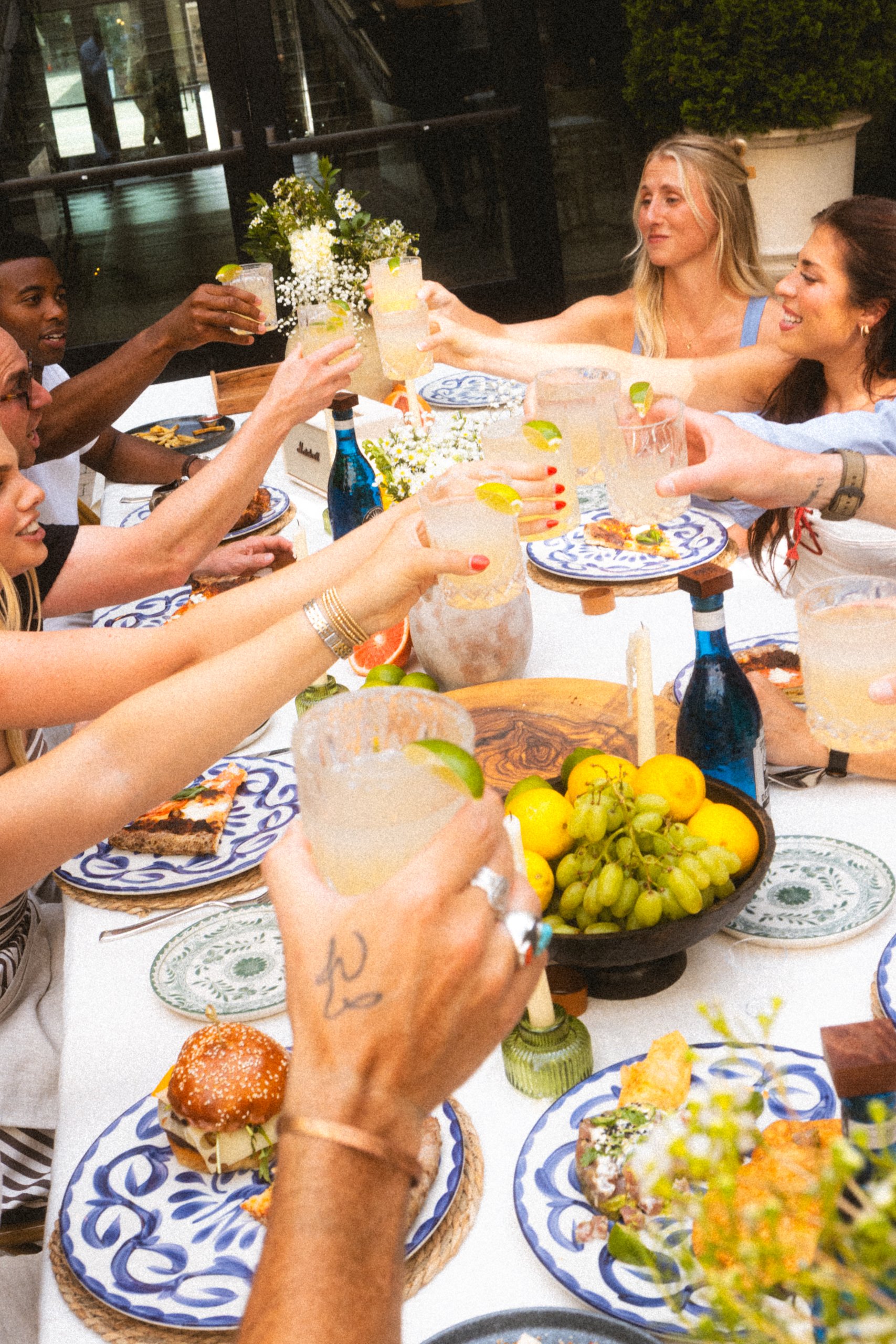 A group of friends cheers with cocktails at an outdoor dinner party in Williamson County, Tennessee.