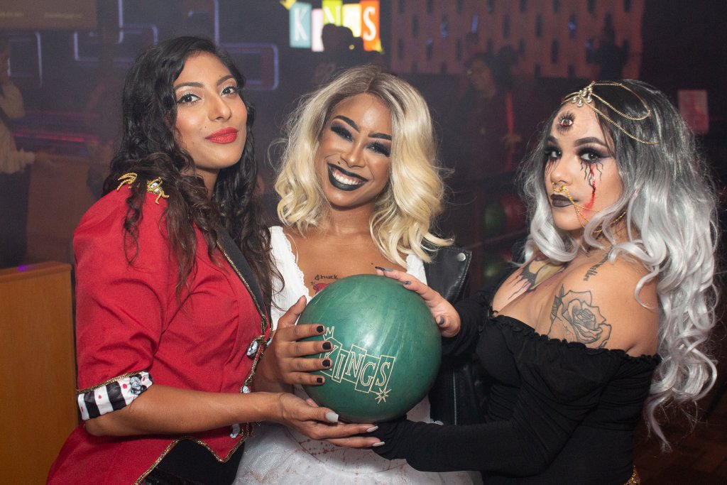 Halloween at Kings Three women in costumes holding a green bowling ball at a bowling alley in Williamson County, Tennessee.