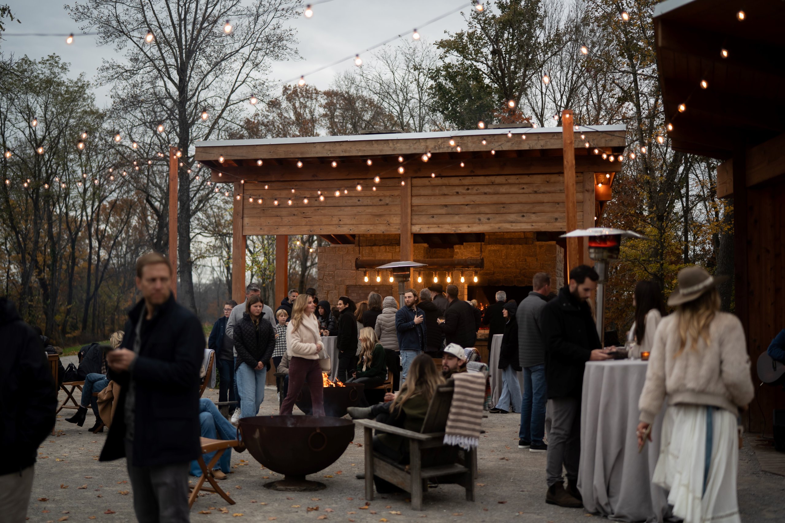 A group of people socializing at an outdoor evening event with string lights in Williamson County, Tennessee.