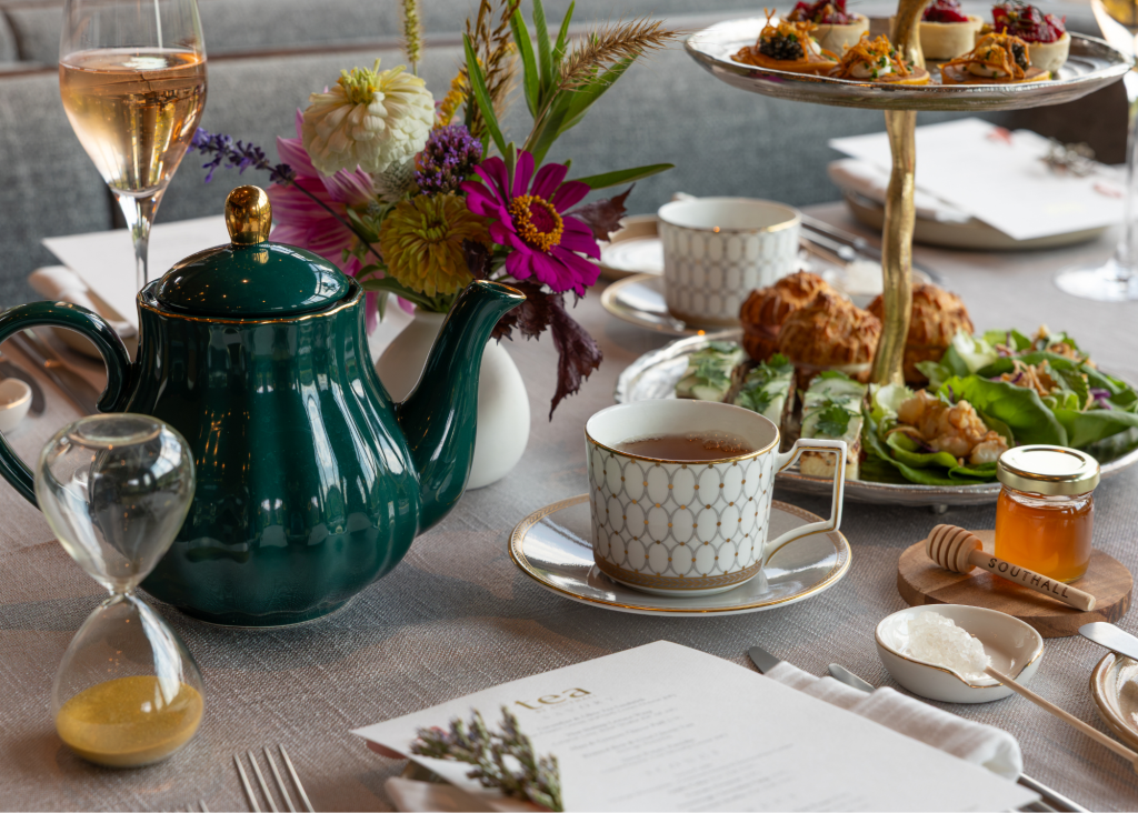 An elegant afternoon tea service with a green teapot, teacups, and tiered food stand in Williamson County, Tennessee.