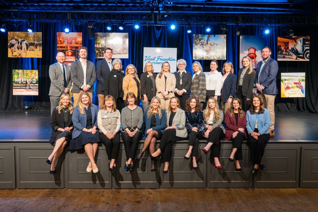 VISIT FRANKLIN NAMED DESTINATION MARKETING ORGANIZATION OF THE YEAR FOR SECOND CONSECUTIVE TIME A large group of professional men and women posing for a photo on stage in Williamson County, Tennessee.