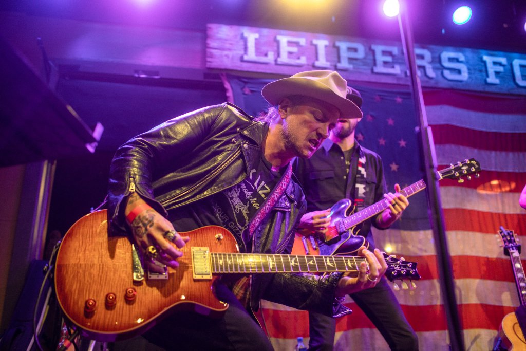 Discover the Surprisingly Unique Music History of Franklin, Tennessee A musician in a hat and leather jacket plays an electric guitar on stage in Williamson County, Tennessee.