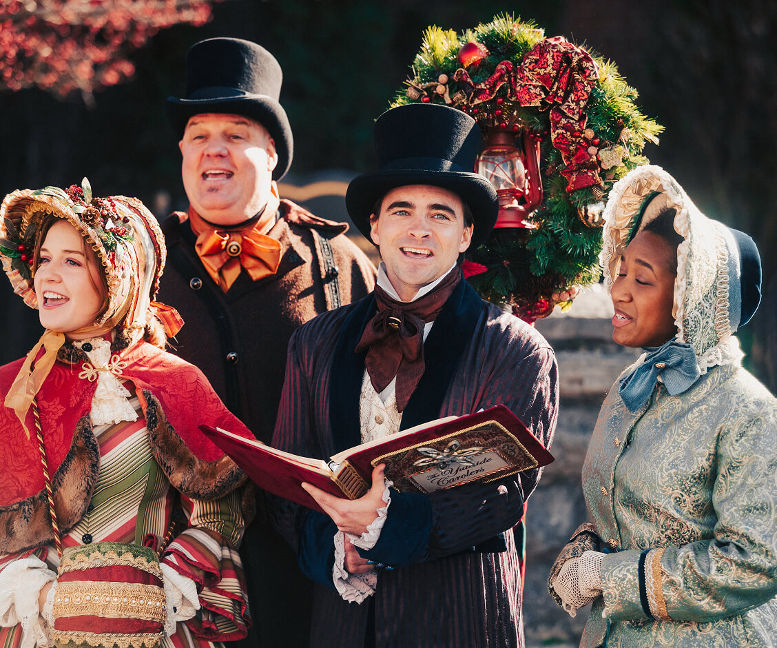 A Hallmark Christmas Escape Four people in Victorian-era costumes singing Christmas carols together outdoors in Williamson County, Tennessee.