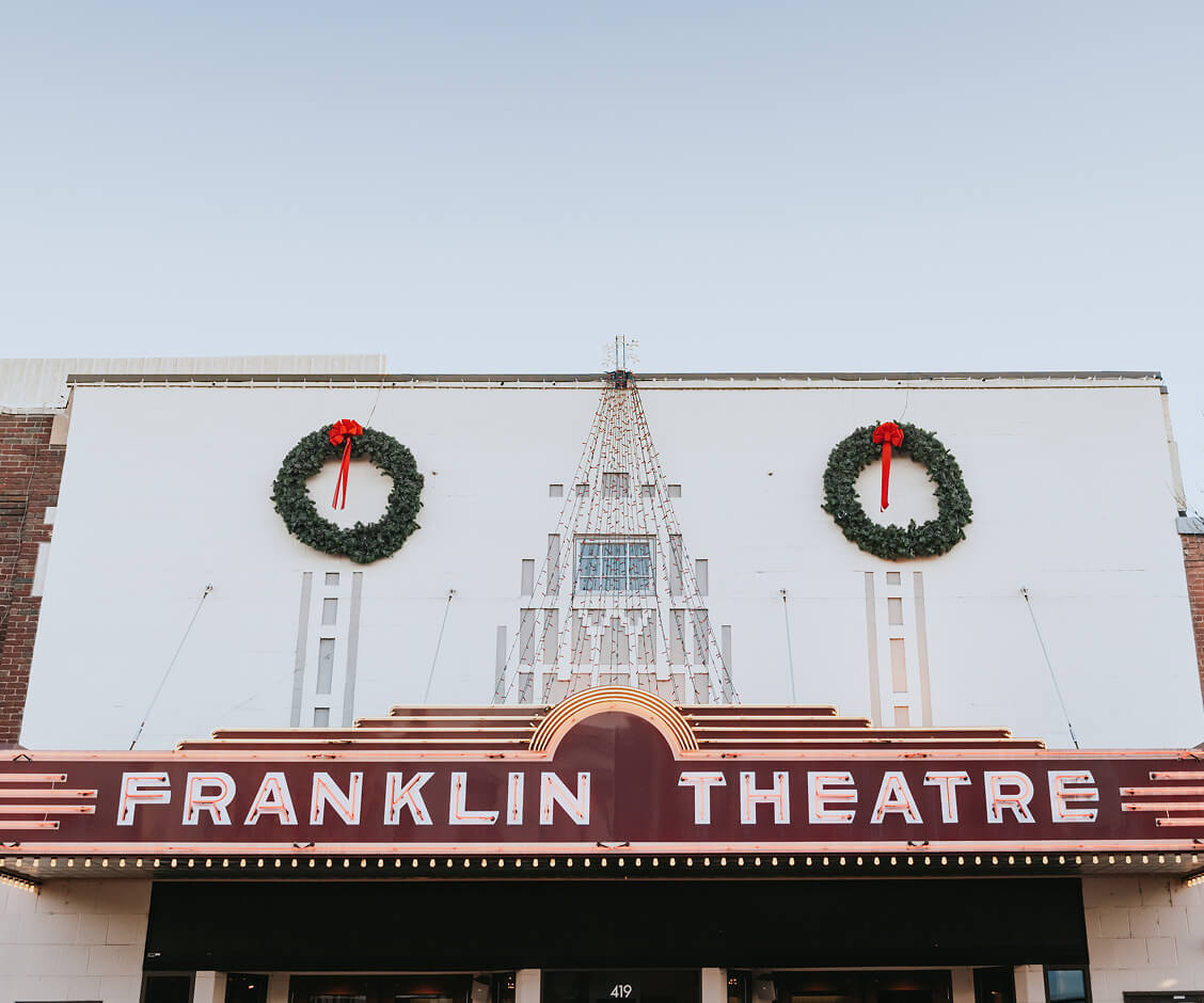 A Hallmark Christmas Escape The Franklin Theatre marquee decorated with two large Christmas wreaths and string lights in Williamson County, Tennessee.