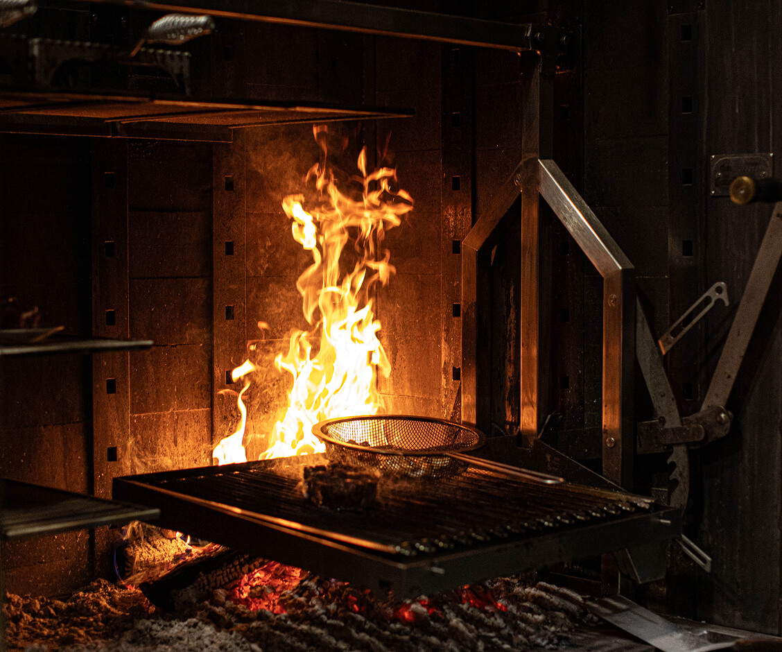 A Hallmark Christmas Escape A piece of meat cooking on a metal grill over an open fire in Williamson County, Tennessee.