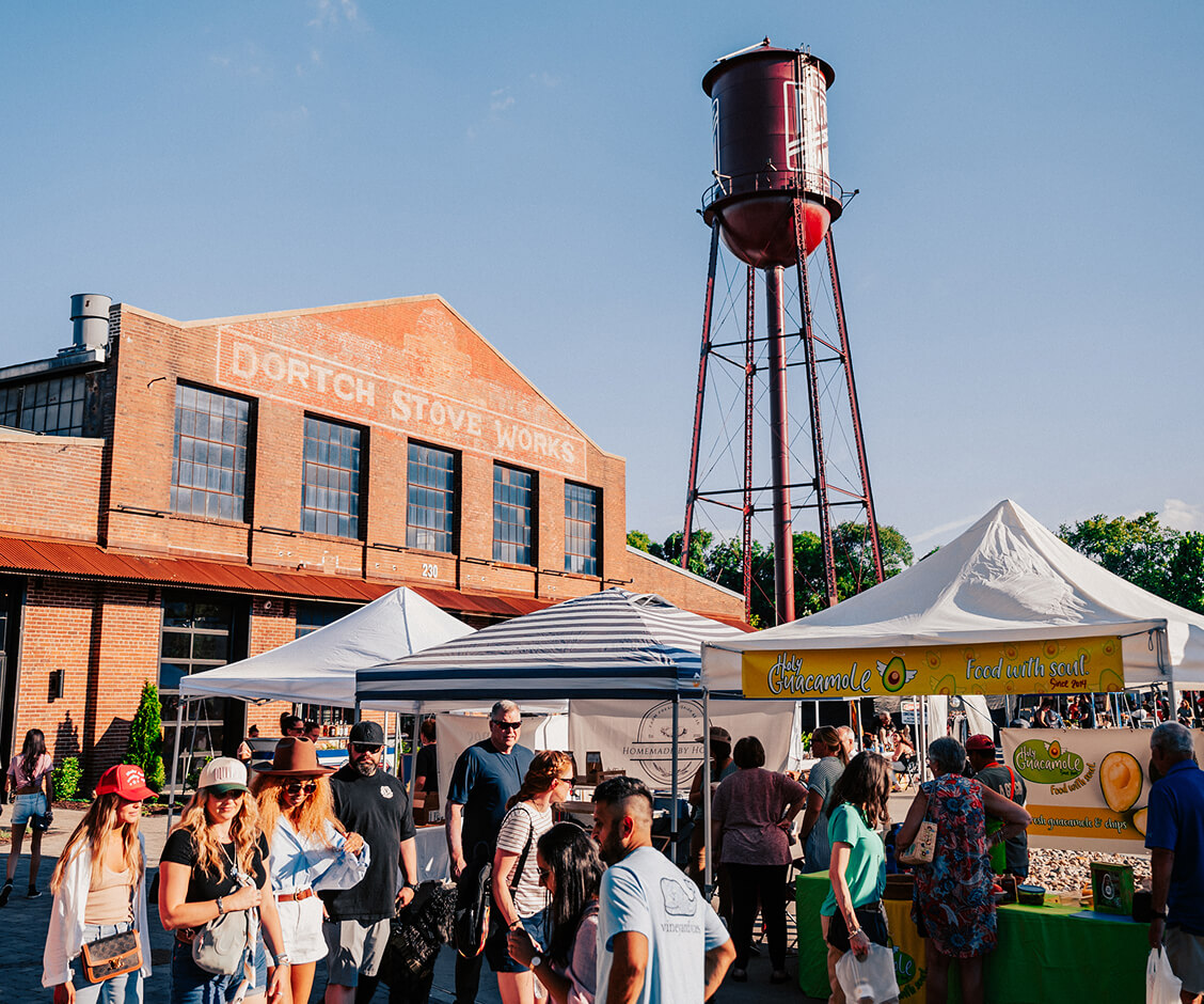 Visitor Center People walking through an outdoor market in front of a brick building and water tower in Williamson County, Tennessee.