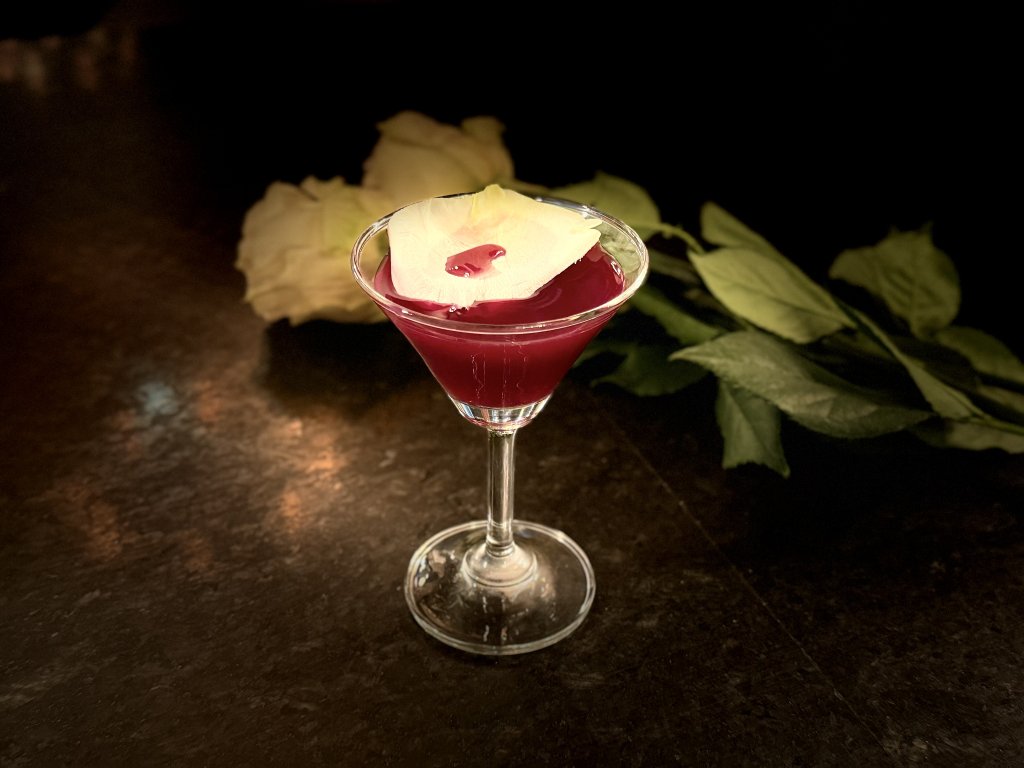 7 Delightfully Spooky Halloween Activities To Do This Season in Franklin, Tennessee A red cocktail in a martini glass garnished with a single white rose petal in Williamson County, Tennessee.