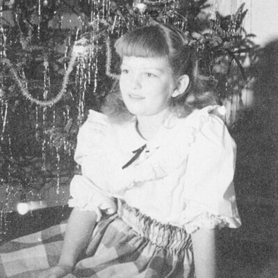 A Family Recipe, a Famous Bakery, and a Franklin Story: The Makings of Merridee's Breadbasket A young girl with bangs sits in front of a decorated Christmas tree in Williamson County, Tennessee.