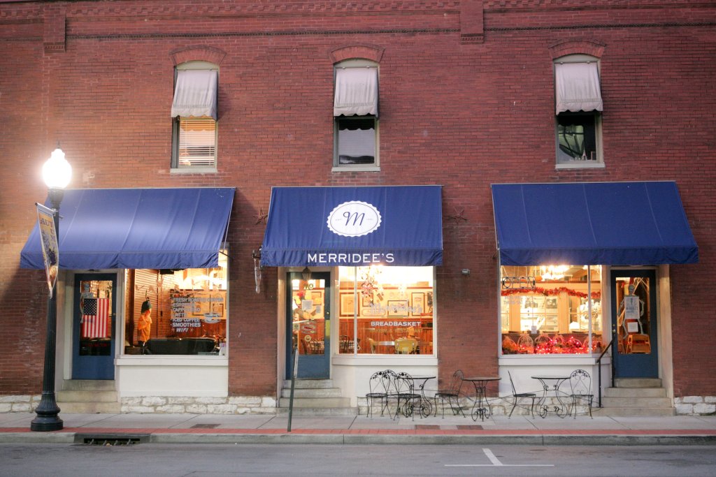 A Family Recipe, a Famous Bakery, and a Franklin Story: The Makings of Merridee's Breadbasket A brick building storefront named Merridee's with blue awnings and outdoor cafe seating in Williamson County, Tennessee.