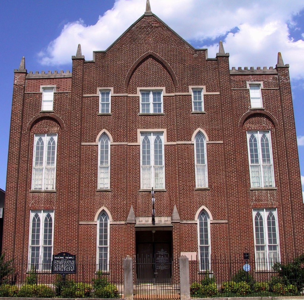 A historic red brick Masonic Temple building with gothic arched windows under a blue sky in Williamson County, Tennessee.