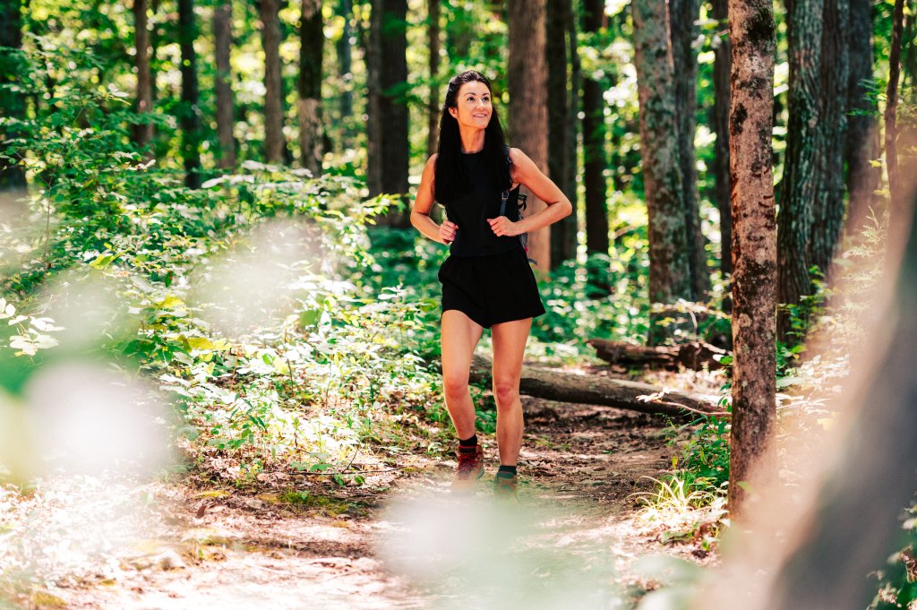 Hiding in Plain Sight: The Fascinating Native American History Found in Franklin, Tennessee A woman with a backpack hiking along a sunny forest trail in Williamson County, Tennessee.