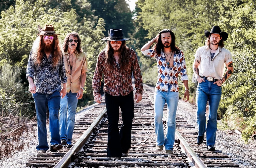 ForkFest 2026 Features Hippies & Cowboys Five men in vintage-style clothing walking along railroad tracks in a wooded area in Williamson County, Tennessee.