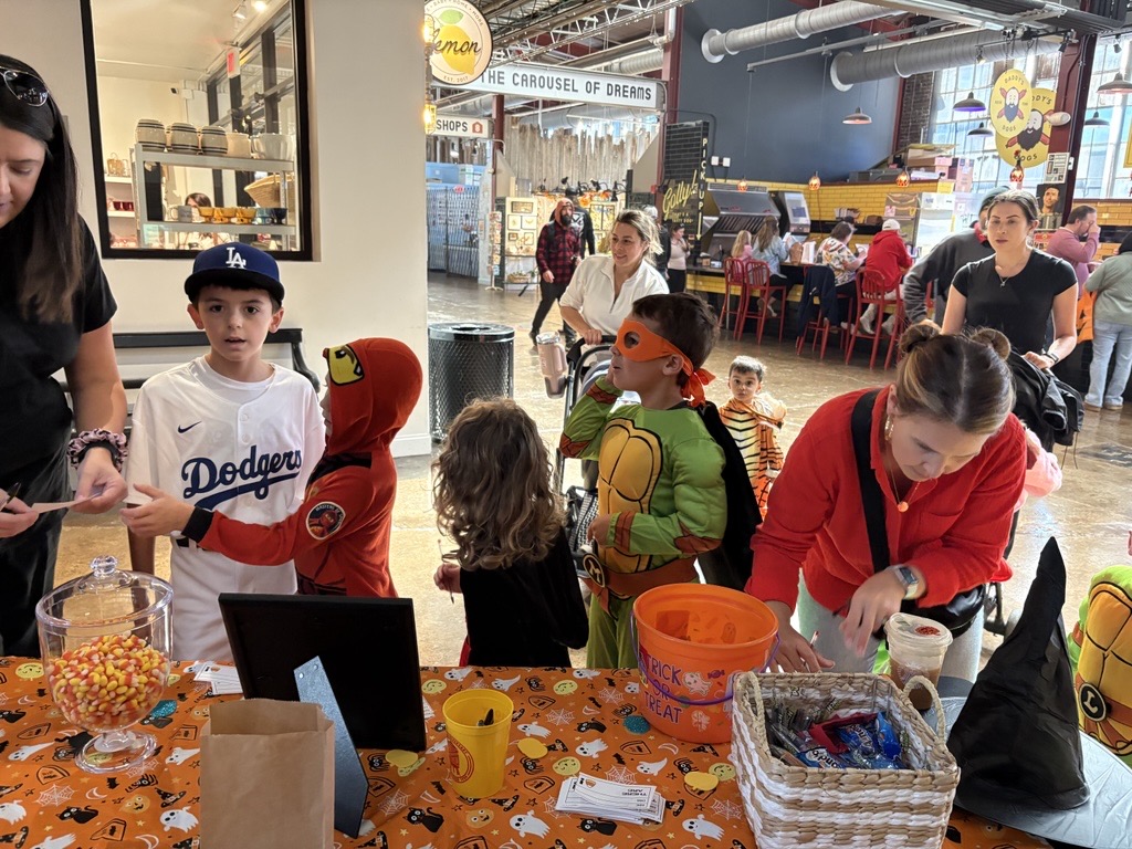 Trick-or-Treat Trail at The Factory Children in costumes gather around a table with candy at an indoor event in Williamson County, Tennessee.