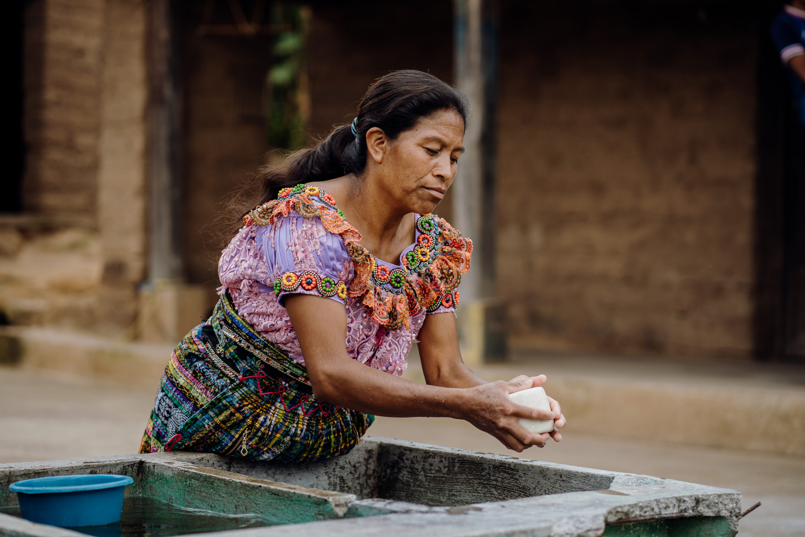 A community member washes her hands outside her home in Santa Cruz del Quiché, Guatemala.