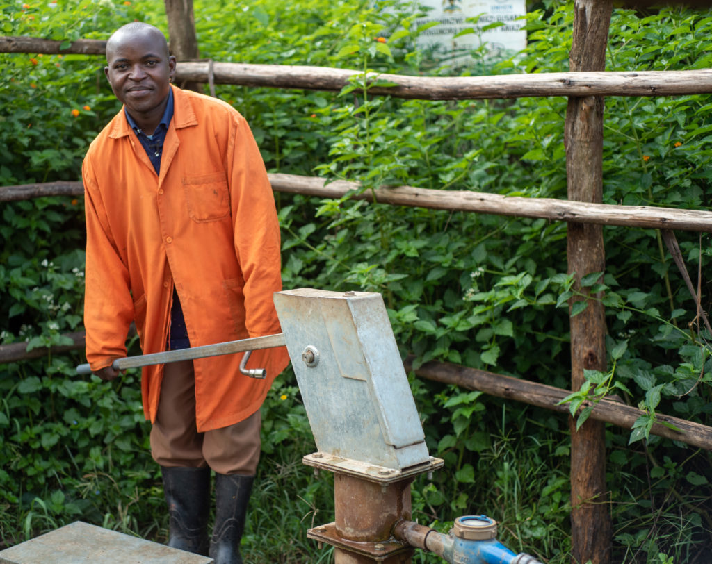 Paul, a hand pump mechanic, works on a pump in Kamwenge